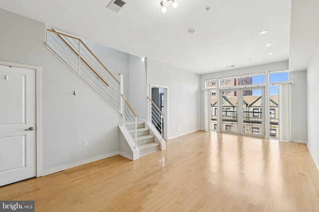 1209 N Charles St Unit 409, Baltimore, MD 21201 - unfurnished living room featuring stairway, wood finished floors, and recessed lighting