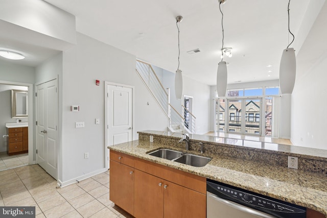 1209 N Charles St Unit 409, Baltimore, MD 21201 - kitchen with stainless steel dishwasher, light tile patterned floors, light stone counters, brown cabinetry, and open floor plan