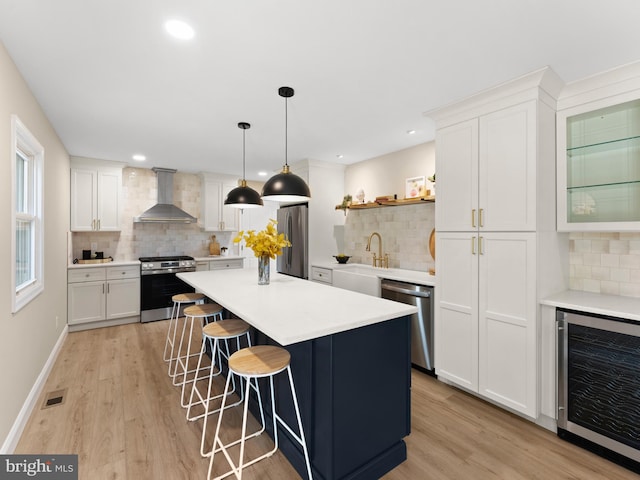 713 Franklinville Rd, Mullica Hill, NJ 08062 - kitchen with beverage cooler, appliances with stainless steel finishes, wall chimney range hood, decorative backsplash, and a breakfast bar area