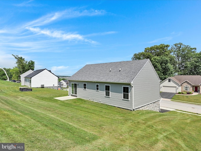 566 Monocacy Trl, Spring Grove, PA 17362 - rear view of house with a yard, roof with shingles, and a detached garage
