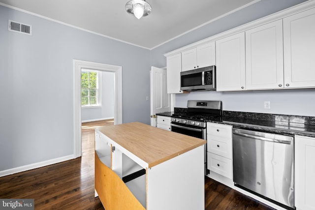 239 W Lafayette Ave, Baltimore, MD 21217 - kitchen with appliances with stainless steel finishes, dark wood-style flooring, ornamental molding, white cabinetry, and wooden counters