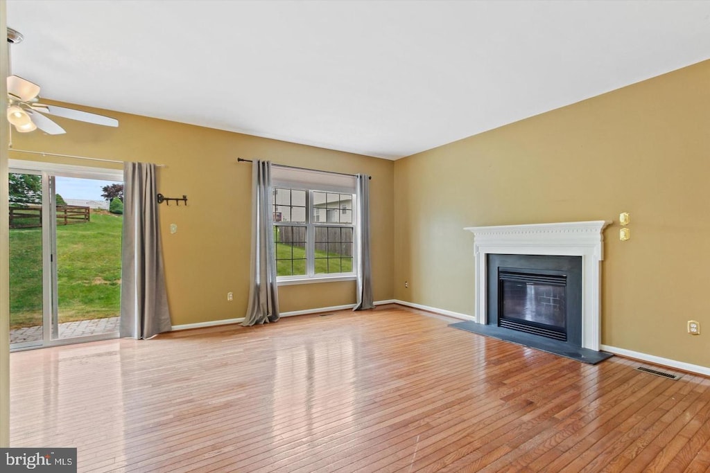 38 Menlena Cir, Hanover, PA 17331 - unfurnished living room featuring hardwood / wood-style flooring, a ceiling fan, and a glass covered fireplace