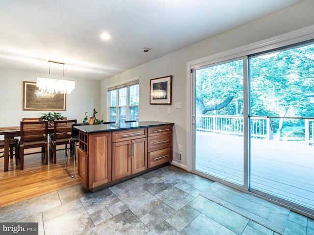 14901 Joshua Tree Rd, North Potomac, MD 20878 - kitchen featuring dark countertops, a chandelier, healthy amount of natural light, and brown cabinets