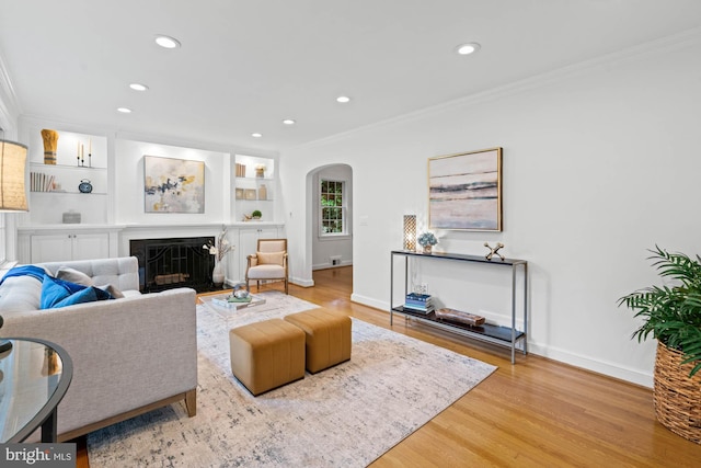 2723 Washington Ave, Chevy Chase, MD 20815 - living area featuring arched walkways, crown molding, wood finished floors, recessed lighting, and a fireplace