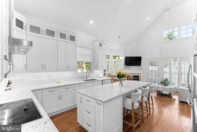10111 Ballynahown Cir, Fairfax, VA 22030 - kitchen featuring black electric stovetop, high vaulted ceiling, a center island, tasteful backsplash, and white cabinetry