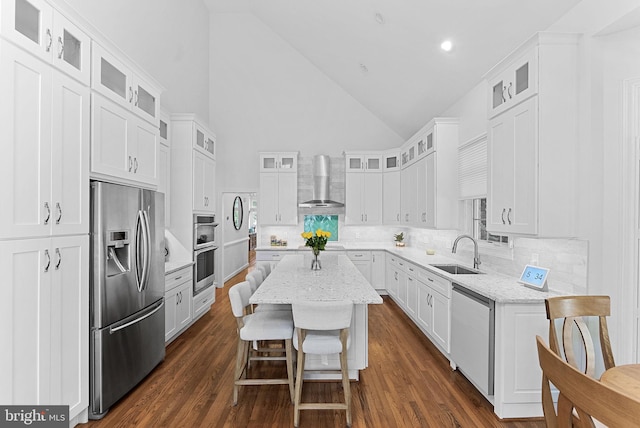 10111 Ballynahown Cir, Fairfax, VA 22030 - kitchen with stainless steel appliances, wall chimney range hood, high vaulted ceiling, a kitchen island, and tasteful backsplash