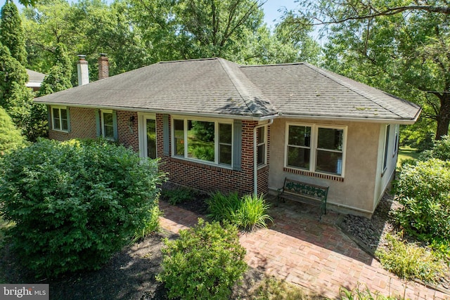 860 Temple Rd, Pottstown, PA 19465 - view of front of home featuring roof with shingles, a chimney, brick siding, stucco siding, and view of wooded area