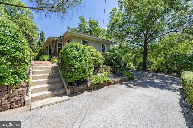 860 Temple Rd, Pottstown, PA 19465 - view of property hidden behind natural elements featuring stairway, stucco siding, and driveway