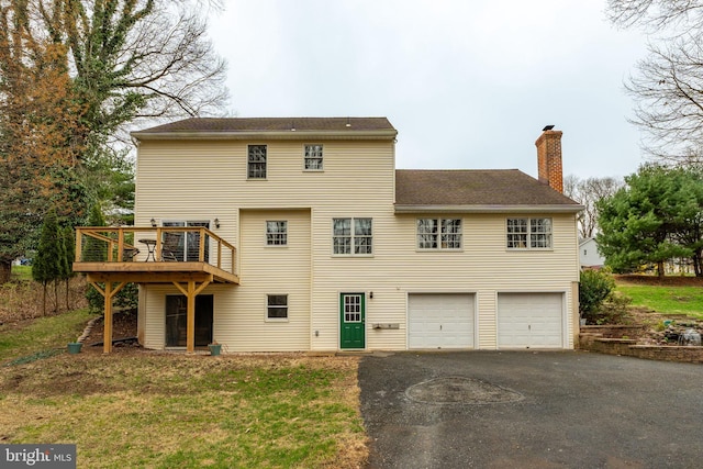 5 Charcoal Ln, Mohnton, PA 19540 - rear view of house featuring a chimney, asphalt driveway, an attached garage, a wooden deck, and roof with shingles