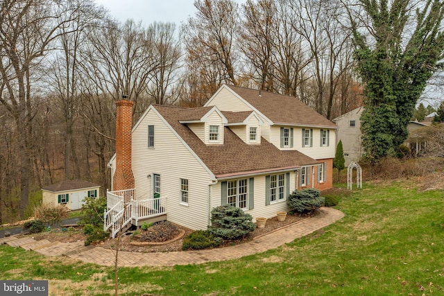 5 Charcoal Ln, Mohnton, PA 19540 - view of front facade featuring a chimney, an outdoor structure, a shingled roof, a front lawn, and a deck