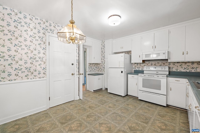 608 Davis Ave, Charlottesville, VA 22901 - kitchen featuring white appliances, wallpapered walls, a chandelier, dark countertops, and white cabinetry