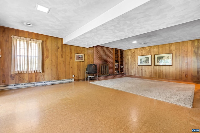 608 Davis Ave, Charlottesville, VA 22901 - below grade area featuring a baseboard heating unit, tile patterned floors, wood walls, a wood stove, and a textured ceiling