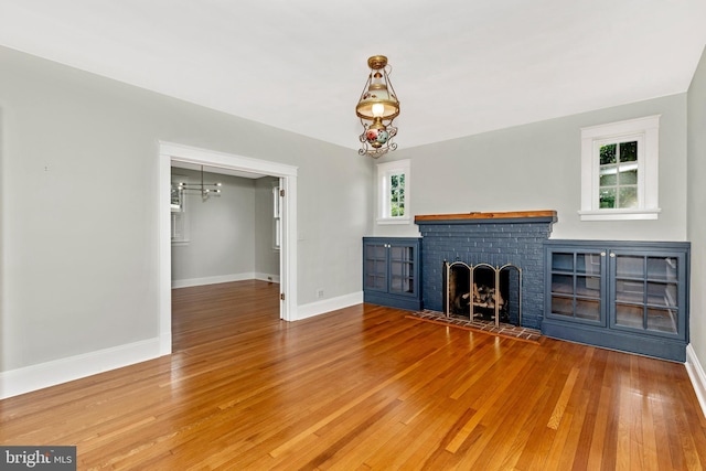301 Fleming Ave, Frederick, MD 21701 - unfurnished living room featuring a fireplace, wood finished floors, and plenty of natural light