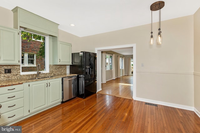 301 Fleming Ave, Frederick, MD 21701 - kitchen with stainless steel dishwasher, black fridge, hardwood / wood-style floors, tasteful backsplash, and recessed lighting