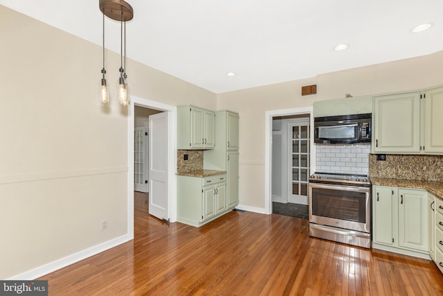 301 Fleming Ave, Frederick, MD 21701 - kitchen with black microwave, electric range, tasteful backsplash, wood-type flooring, and pendant lighting