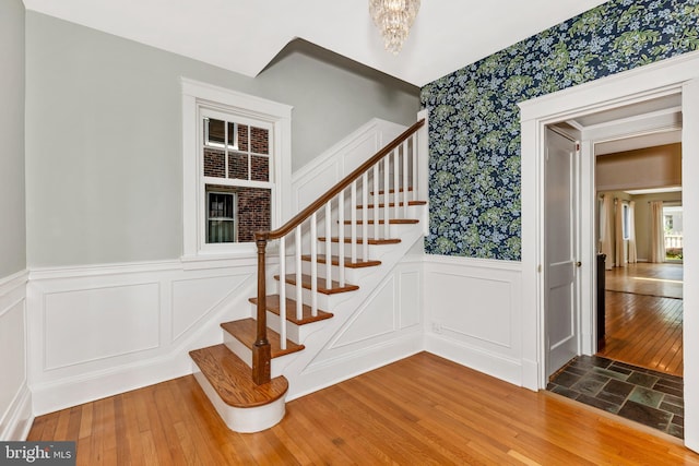 301 Fleming Ave, Frederick, MD 21701 - stairway with wallpapered walls, wainscoting, a decorative wall, and wood-type flooring