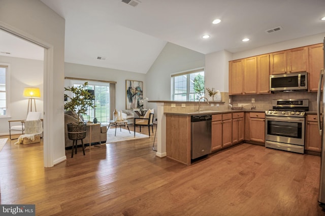 44357 Oakmont Manor Sq, Ashburn, VA 20147 - kitchen featuring appliances with stainless steel finishes, wood finished floors, plenty of natural light, vaulted ceiling, and recessed lighting