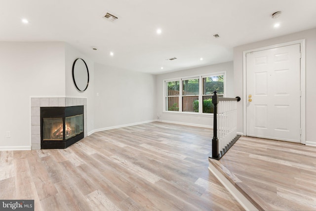 12560 Kempston Ln, Woodbridge, VA 22192 - unfurnished living room featuring recessed lighting, light wood-style floors, and a tile fireplace
