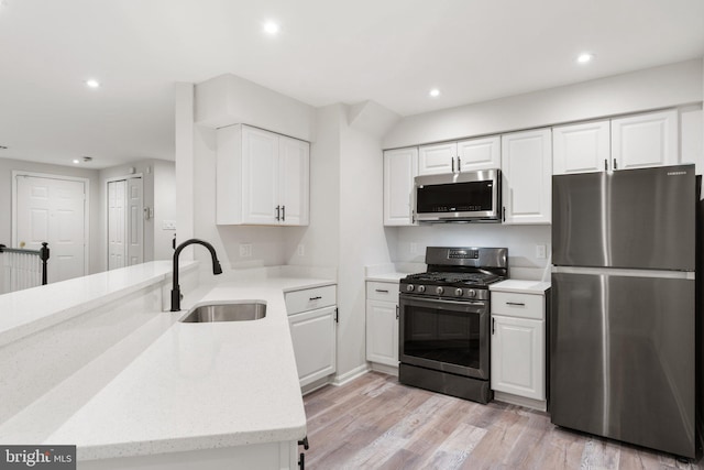 12560 Kempston Ln, Woodbridge, VA 22192 - kitchen featuring stainless steel appliances, a peninsula, white cabinets, recessed lighting, and light stone countertops