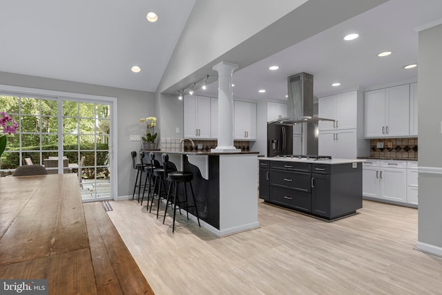 13 Weirwood Rd, Wayne, PA 19087 - kitchen with island exhaust hood, decorative backsplash, light wood finished floors, white cabinetry, and recessed lighting