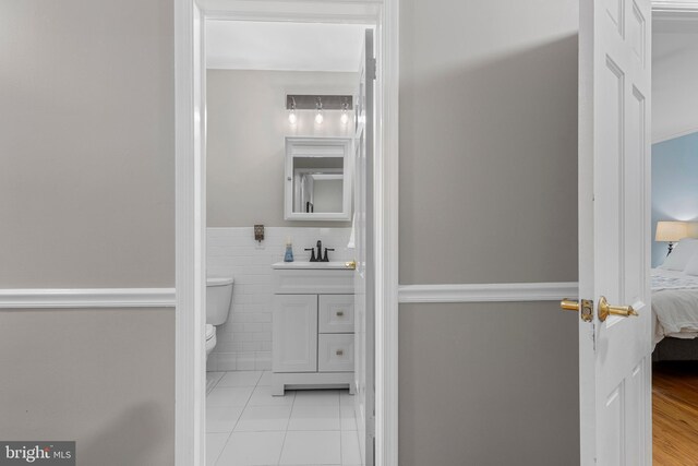 13 Weirwood Rd, Wayne, PA 19087 - ensuite bathroom with vanity, tile patterned flooring, tile walls, and a wainscoted wall