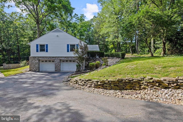 13 Weirwood Rd, Wayne, PA 19087 - view of property exterior with asphalt driveway, an attached garage, stone siding, and a yard
