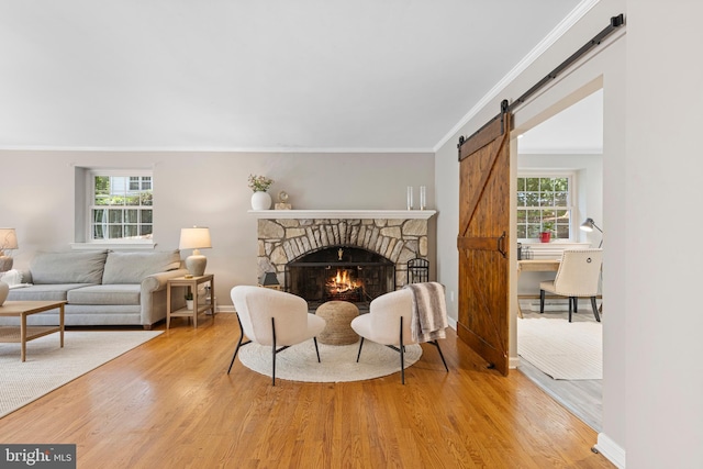 13 Weirwood Rd, Wayne, PA 19087 - sitting room with a barn door, light wood-type flooring, ornamental molding, and a stone fireplace