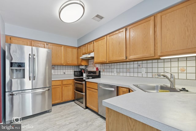 243 Prince William Way, Chalfont, PA 18914 - kitchen featuring stainless steel appliances, light countertops, under cabinet range hood, light wood-type flooring, and backsplash