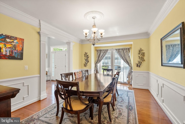 14512 Penderlea Ct, Gainesville, VA 20155 - dining area with a chandelier, wainscoting, light wood-style floors, ornamental molding, and ornate columns