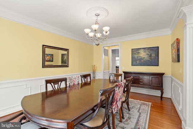 14512 Penderlea Ct, Gainesville, VA 20155 - dining space featuring a chandelier, ornamental molding, wood finished floors, wainscoting, and a decorative wall