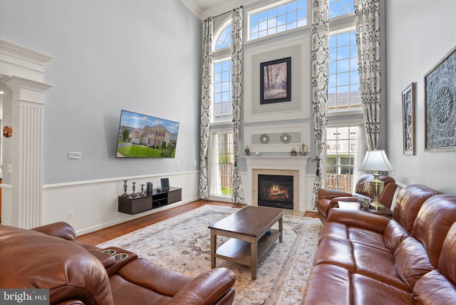 14512 Penderlea Ct, Gainesville, VA 20155 - living room featuring a high ceiling, wood finished floors, decorative columns, a fireplace with flush hearth, and crown molding