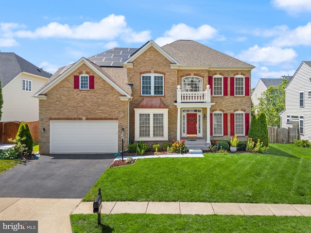 14512 Penderlea Ct, Gainesville, VA 20155 - colonial home featuring driveway, an attached garage, brick siding, solar panels, and roof with shingles