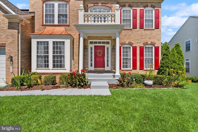 14512 Penderlea Ct, Gainesville, VA 20155 - view of front of house with brick siding, a balcony, and a front lawn