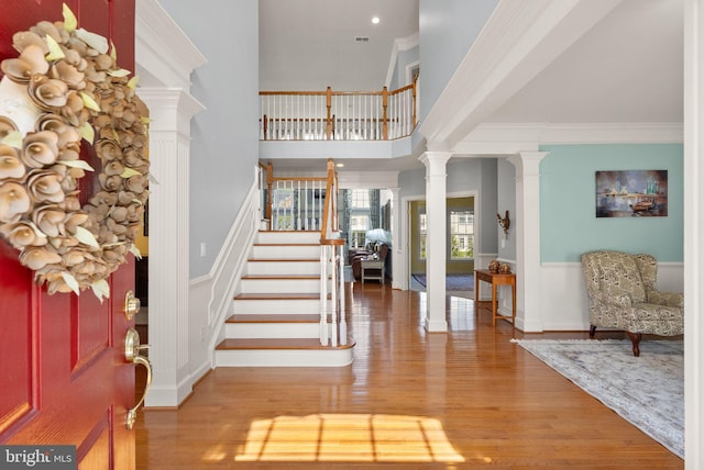 14512 Penderlea Ct, Gainesville, VA 20155 - entrance foyer with ornate columns, stairway, wood finished floors, ornamental molding, and a wainscoted wall