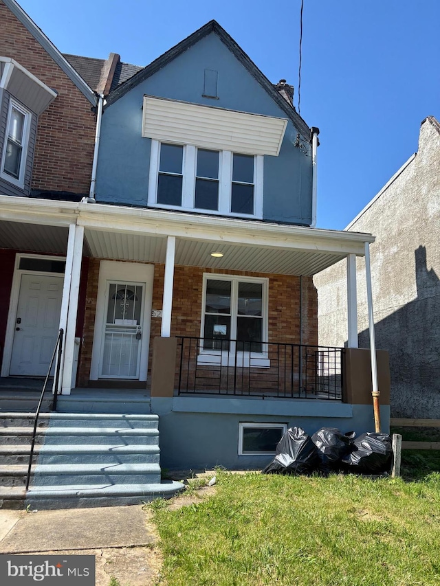 5236 Cedar Ave, Philadelphia, PA 19143 - view of front of property featuring covered porch, brick siding, and a front yard