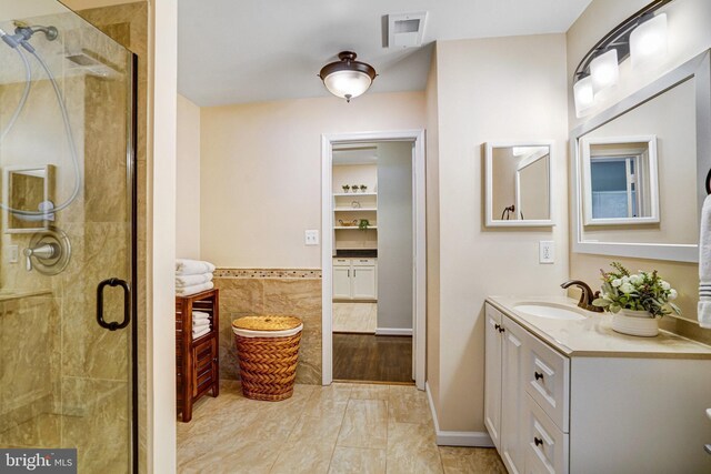 6532 Grange Ln Unit 103, Alexandria, VA 22315 - full bath featuring tile walls, vanity, a stall shower, and a wainscoted wall