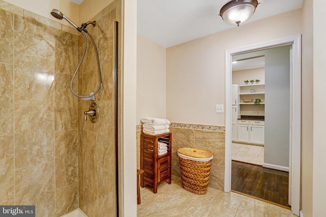 6532 Grange Ln Unit 103, Alexandria, VA 22315 - bathroom with a tile shower, tile walls, and a wainscoted wall