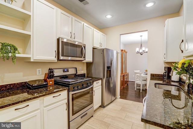 6532 Grange Ln Unit 103, Alexandria, VA 22315 - kitchen with open shelves, appliances with stainless steel finishes, a chandelier, white cabinets, and dark stone countertops