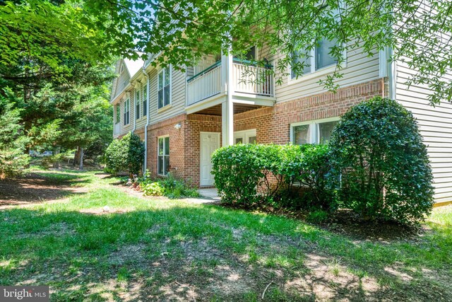 6532 Grange Ln Unit 103, Alexandria, VA 22315 - view of home's exterior featuring a balcony, brick siding, and a lawn