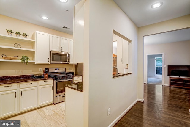 6532 Grange Ln Unit 103, Alexandria, VA 22315 - kitchen featuring appliances with stainless steel finishes, light wood-type flooring, dark stone countertops, white cabinets, and recessed lighting
