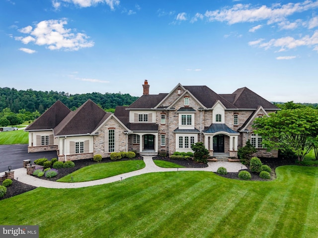 2740 Allen Glen Dr, Mechanicsburg, PA 17055 - view of front of house featuring stone siding, a chimney, a front lawn, and a standing seam roof