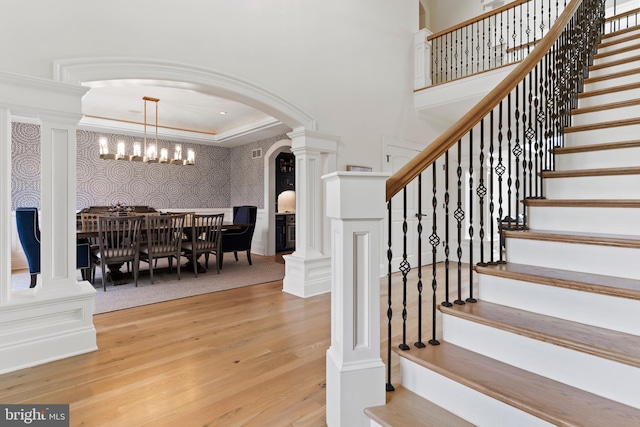 2740 Allen Glen Dr, Mechanicsburg, PA 17055 - staircase featuring wood finished floors, arched walkways, ornate columns, ornamental molding, and a chandelier