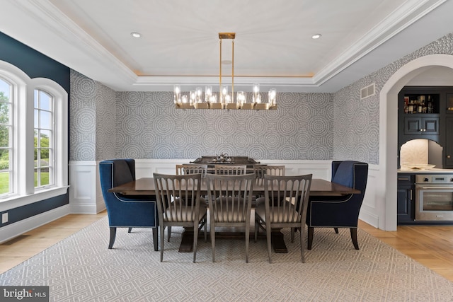 2740 Allen Glen Dr, Mechanicsburg, PA 17055 - dining room featuring a raised ceiling, a chandelier, wallpapered walls, a wainscoted wall, and arched walkways