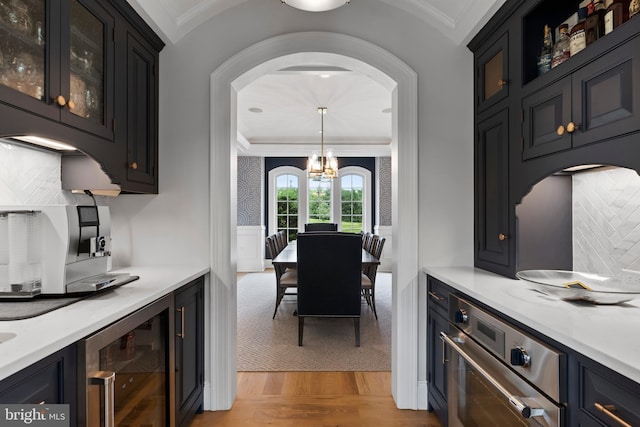 2740 Allen Glen Dr, Mechanicsburg, PA 17055 - kitchen with beverage cooler, ornamental molding, arched walkways, light wood-style flooring, and light countertops