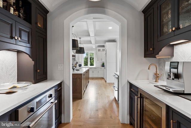 2740 Allen Glen Dr, Mechanicsburg, PA 17055 - bar area featuring wine cooler, light wood finished floors, tasteful backsplash, coffered ceiling, and arched walkways