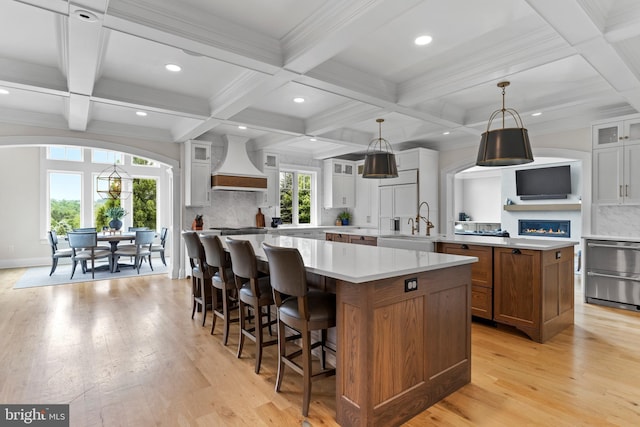 2740 Allen Glen Dr, Mechanicsburg, PA 17055 - kitchen with premium range hood, a large island, coffered ceiling, light wood-style floors, and tasteful backsplash