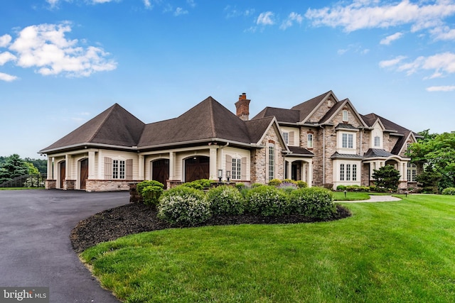 2740 Allen Glen Dr, Mechanicsburg, PA 17055 - view of front facade featuring stone siding, a front lawn, a chimney, and driveway