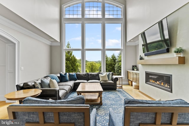 2740 Allen Glen Dr, Mechanicsburg, PA 17055 - living room with a towering ceiling, a glass covered fireplace, light wood finished floors, and ornamental molding