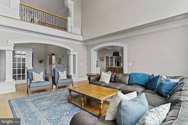 2740 Allen Glen Dr, Mechanicsburg, PA 17055 - living room with decorative columns, arched walkways, a towering ceiling, wood finished floors, and ornamental molding