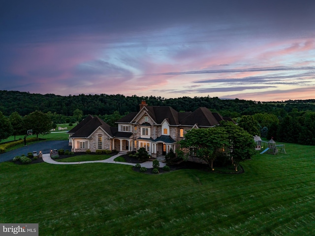 2740 Allen Glen Dr, Mechanicsburg, PA 17055 - view of front of house featuring stone siding, a playground, a chimney, a front lawn, and a view of trees